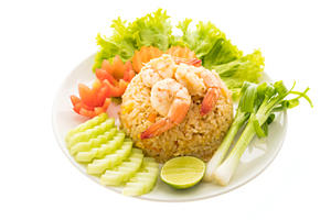 Fried rice with shrimp and prawn on top in white plate